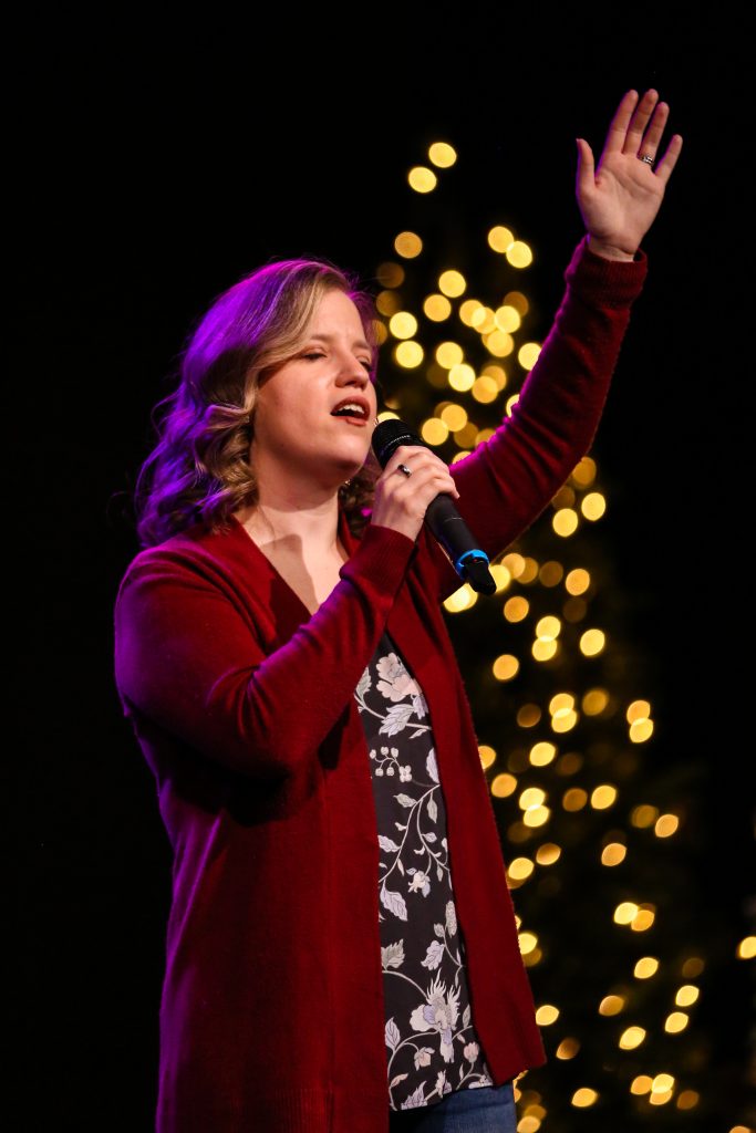 Tatiana Dunnett singing with lights in the background