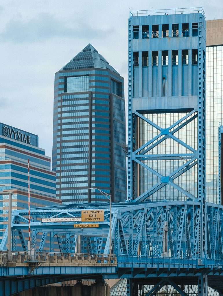 Stunning view of the iconic blue Main Street Bridge (John T. Alsop Jr. Bridge) in downtown Jacksonville, Florida. Features the VyStar Tower and Wells Fargo Center against the city skyline.